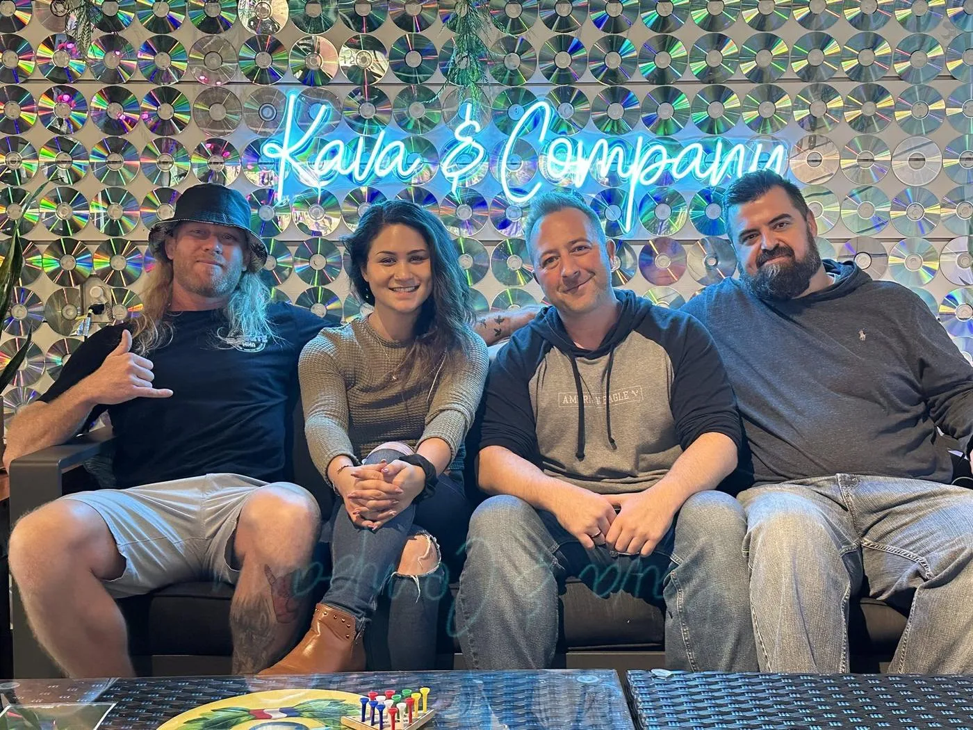 Regulars relaxing on the couch under the Kava & Company wall